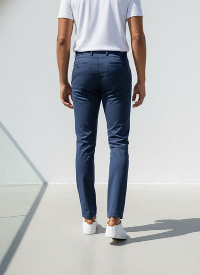 Person wearing navy pants and white shoes on a light background