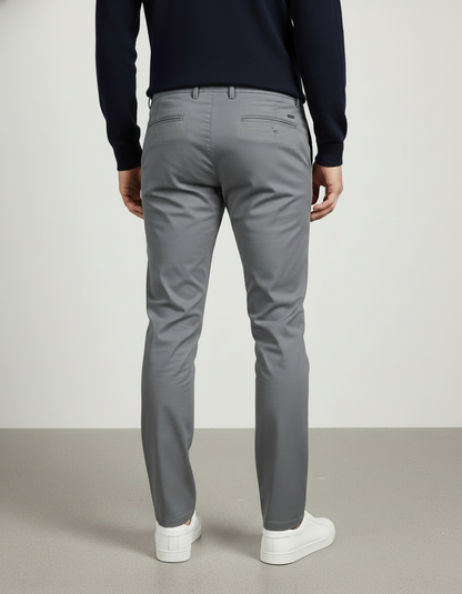 Person wearing gray pants and a navy sweater on a plain background